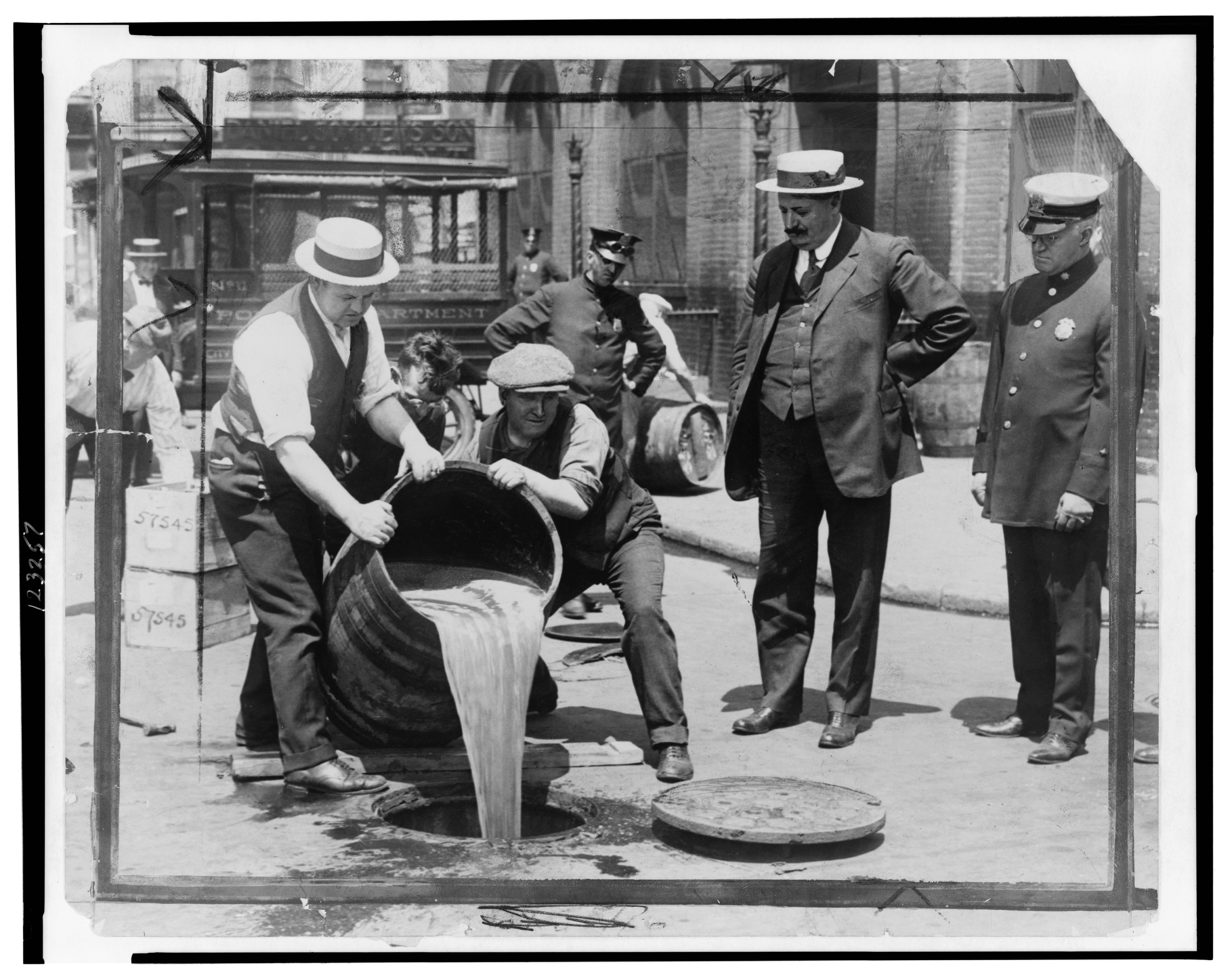Prohibition agents pour confiscated liquor into a New York City sewer, 1921 (Library of Congress, public domain)